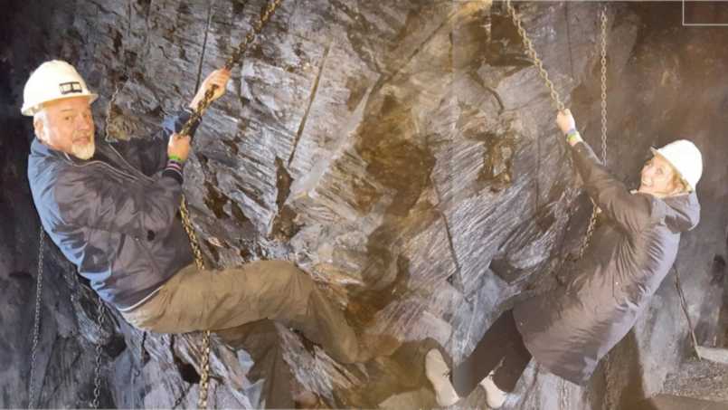 David and Rachel hanging from a rock face by a chain